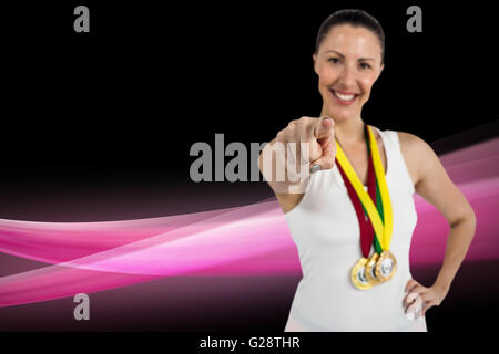 Image composite de l'athlète féminin posant avec des médailles d'or autour du cou Banque D'Images