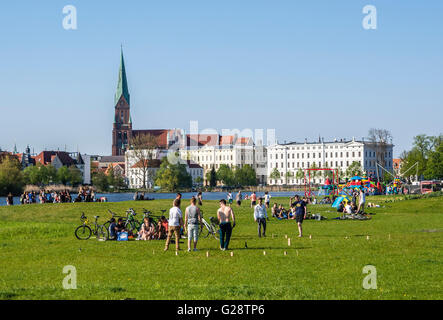 Au château de Schwerin, parc personnes jouant sur l'herbe, de la cathédrale à l'arrière, Schwerin, Allemagne Banque D'Images