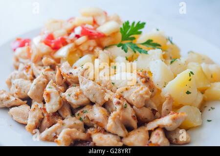 Pépites de poulet au curry avec des pommes de terre et les légumes sur la plaque Banque D'Images