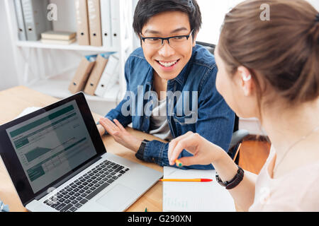 Deux happy young businesspeople using laptop et travailler ensemble Banque D'Images