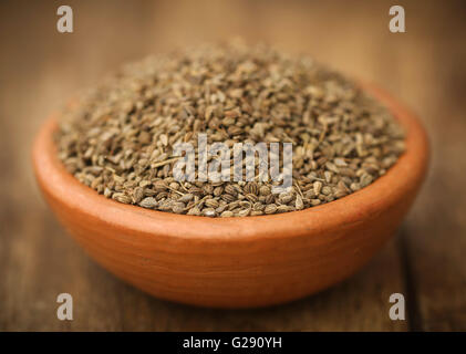 Les graines d'Ajwain en poterie sur surface en bois Banque D'Images