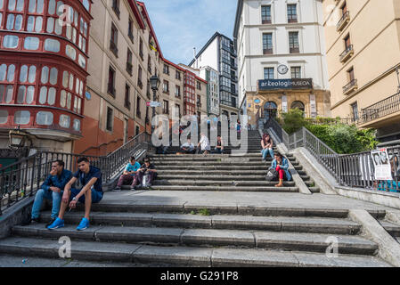 Les gens assis sur les marches menant au large de Miguel de Unamuno plaza, Casco Viejo, Bilbao, Espagne Banque D'Images