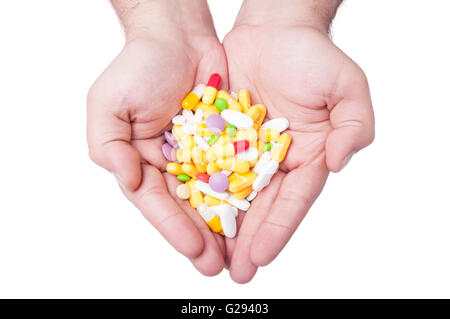 Un homme organise un grand nombre de différentes pilules dans ses deux mains Banque D'Images