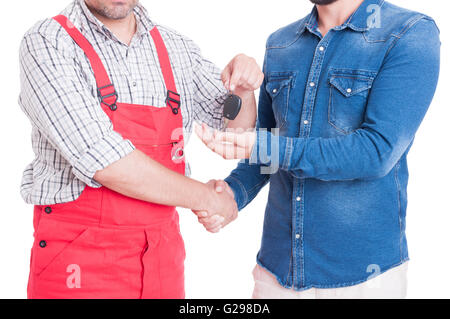 Mécanicien anonyme remise car key au client ou client isolated on white Banque D'Images