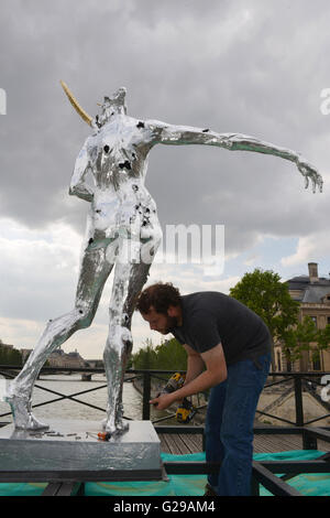 Paris, France. 25 mai, 2016. Un travailleur les plans tremblotants une statue lors d'une exposition d'œuvres de l'artiste français Daniel Hourde sur pont Pont des Arts à Paris, France, le 25 mai 2016. L'exposition se tiendra du 25 mai au 27 juin. Des centaines de milliers de "love locks' ont été une fois accroché sur Pont des Arts pont, une passerelle sur la Seine. © Li Genxing/Xinhua/Alamy Live News Banque D'Images