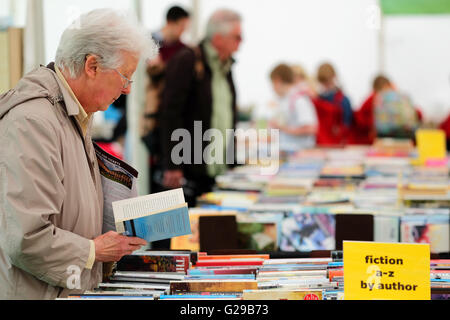 Hay Festival Hay-on-Wye, au Pays de Galles, Royaume-Uni, mai 2016. Jour d'ouverture pour cette années et littéraires arts festival qui se déroule jusqu'au 5 juin. Un visiteur navigue sur la sélection de livres d'occasion à vendre au kiosque d'Oxfam les seuls livres d'occasion sur le site du festival. Banque D'Images