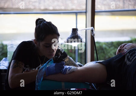 Les tatoueurs travaillent sur les festivaliers au Museu del Disseny, Barcelone, le 28 mai 2016. Le premier jour du festival OFFF (alimentons le futur) à Barcelone. Ce festival de design en est maintenant à sa 16e année. Sur la photo : il y a un salon de tatouage sur place. Crédit : Rob Watkins/Alamy Live News Banque D'Images