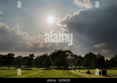 Londres, Royaume-Uni. 26 mai, 2016. Arbres de la lumière du soleil traversant les nuages dans la soirée après une journée chaude sur Clapham Common, London - 26 mai 2016. Crédit : Guy Bell/Alamy Live News Banque D'Images