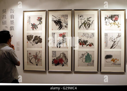 (160527) -- HONG KONG, le 27 mai 2016 (Xinhua) -- Un visiteur examine les oeuvres de Wu Changshuo à un essai de China Guardian Hong Kong 2016 Vente aux enchères du printemps, Hong Kong, Chine du sud, le 27 mai 2016. La vente aux enchères débutera du 29 au 31 mai à Hong Kong avec plus de 1 200 morceaux d'enchères dont les peintures chinoises, calligraphie, céramique et ainsi de suite. (Xinhua/Li Peng) (wyl) Banque D'Images