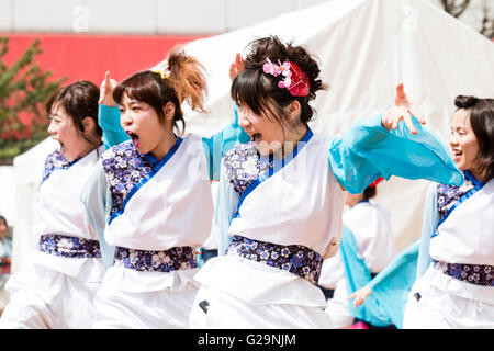 L'équipe des femmes en blanc et turquoise vestes happi, danse en plein air, dans les rangées, au cours de l'Hinokuni danse Yosakoi Festival à Kumamoto, au Japon. Banque D'Images