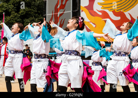 L'équipe des femmes en blanc et turquoise vestes happi, danse en plein air, dans les rangées, au cours de l'Hinokuni danse Yosakoi Festival à Kumamoto, au Japon. Banque D'Images