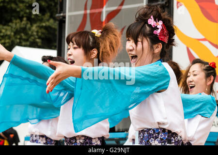 L'équipe des femmes en blanc et turquoise vestes happi, danse en plein air, dans les rangées, au cours de l'Hinokuni danse Yosakoi Festival à Kumamoto, au Japon. Banque D'Images