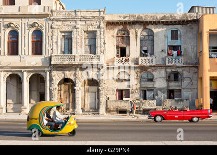 Une Plymouth 1957 convertible et un Coco taxi circulant le long de la jetée à La Havane La Habana, Cuba. Banque D'Images