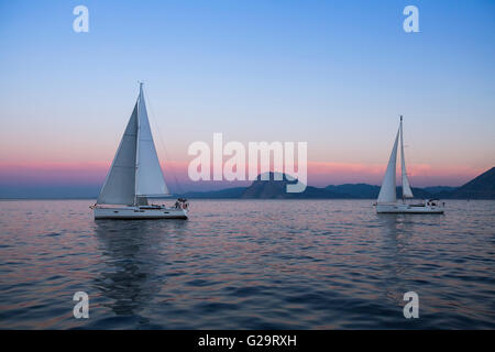 Bateaux près de la côte après l'incroyable coucher du soleil. Banque D'Images