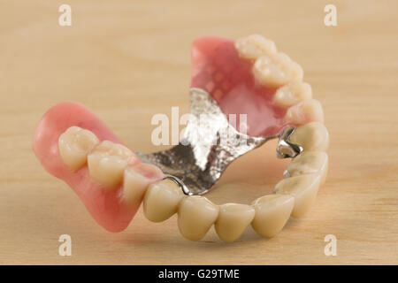 Nouveau dentier avec les couronnes en céramique-métal se coucher sur une table en bois Banque D'Images