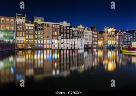 Belles maisons anciennes traditionnelles de nuit à Amsterdam, Pays-Bas. Paysage urbain avec des bâtiments de la ville dans l'eau avec blue Banque D'Images