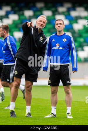 L'entraîneur gardien Maik Taylor pointe vers l'est Chris Baird regarde sur pendant une session de formation à Windsor Park, Belfast. Banque D'Images