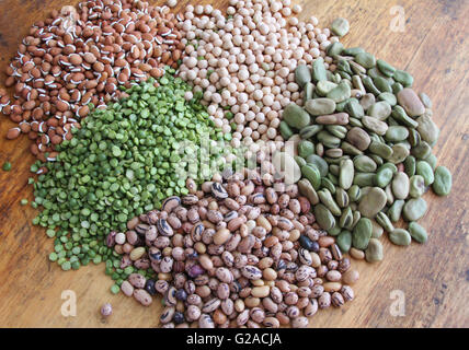 Des tas de haricots et pois secs sur une table en bois rustique Banque D'Images