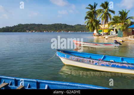 Vieux bateaux amarrés par plage avec palmiers croissant Banque D'Images