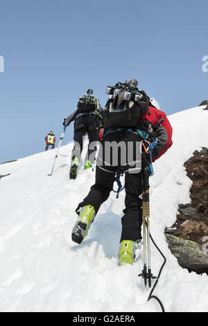 Open Cup de la Russie sur le ski-alpinisme sur le Kamchatka. Team ski alpinisme escalade sur le rocher sur une corde avec skis attachés à un sac à dos. Banque D'Images