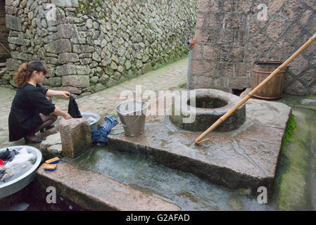 Girl par le bien, West 4th Ring North Cangpo, Province de Zhejiang, Chine Banque D'Images