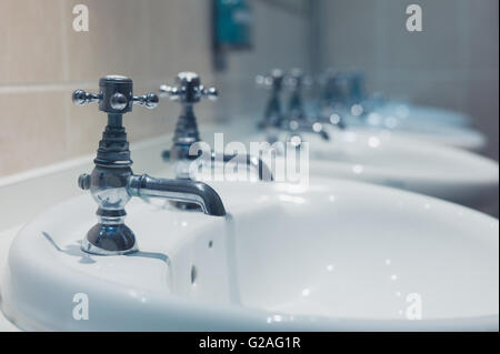 Une rangée de lavabos dans une salle de bains Banque D'Images