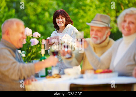 Happy people celebrating birthday avec du vin et des gâteaux dans un jardin Banque D'Images