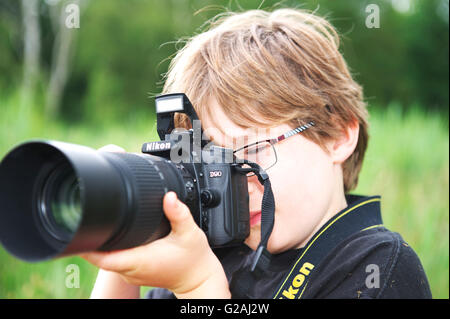 Les Jeunes Anglais Blanc Enfant Tient Un Appareil Photo Avec Un Grand Objectif La Prise De Photographies De La Faune Photo Stock Alamy