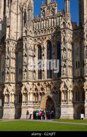 Une visite guidée à l'extérieur de la porte dans le magnifique face ouest de la cathédrale de Wells, Somerset, England, UK Banque D'Images