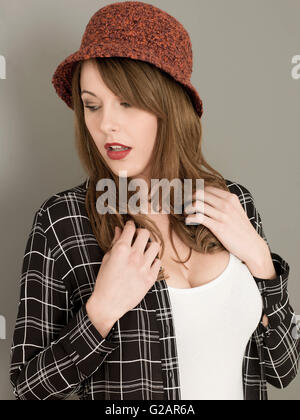 Portrait d'une jeune femme portant un bonnet de laine rouge et une chemise décontractée Banque D'Images