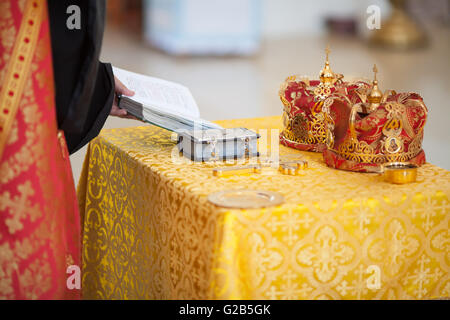 Mariage à l'église orthodoxe - l'attirail croix, bible et couronnes Banque D'Images