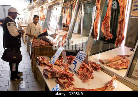 ATHÈNES, Grèce — Un boucher vendant de la viande fraîche à l’Agora Dimotiki, également connue sous le nom d’Agora Varvakios, dans le centre-ville d’Athènes. Le marché est le plus grand marché de détail d'aliments frais de la ville, avec de nombreux étals de boucherie offrant une variété de viandes. L'Agora Dimotiki est une destination populaire pour les habitants et les touristes, mettant en valeur la préparation traditionnelle de la viande grecque et la culture culinaire. Banque D'Images