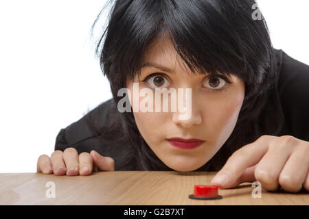 Close up studio shot d'un jeune modèle d'affaires portant un chemisier noir, prêt à appuyer sur un bouton rouge. Isolé sur blanc. Banque D'Images