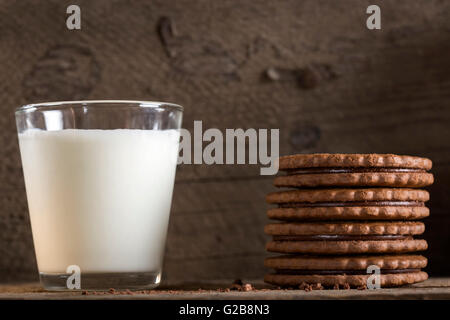 Un verre de lait avec pile de biscuits au chocolat sur la vieille table en bois Banque D'Images