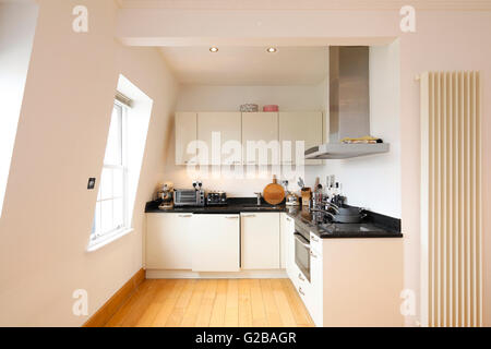 Inverness Terrace. La cuisine propre contemporain avec parquet en bois et le blanc des armoires. Des murs en pente. Banque D'Images