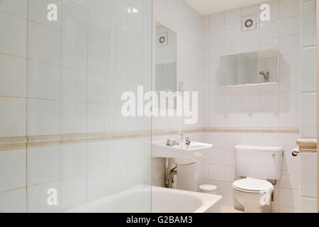 Pembridge Square, Notting Hill. Vue de salle de bains blanc traditionnel avec une porte de douche en verre. Carrelage blanc. Banque D'Images