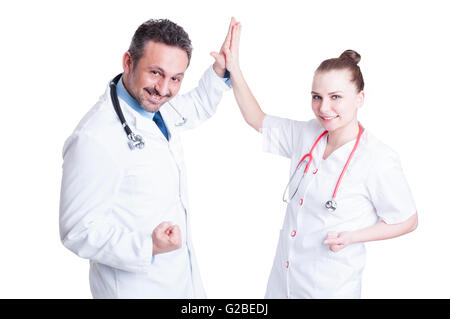 Heureuse équipe les médecins donnent cinq élevé, souriant et célébrer la réussite de travailler ensemble isolé sur fond blanc Banque D'Images