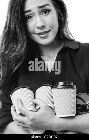 Gros plan d'une belle brune business woman juggling quelques tasses à emporter isolated on white Banque D'Images