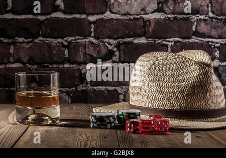 Hat, dés, jetons et de l'alcool sur la table en bois Banque D'Images