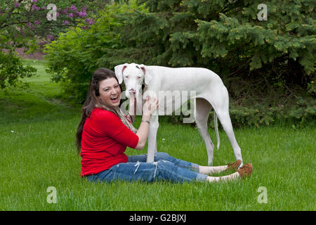 Girl in red rit tout en caressant big dog Banque D'Images