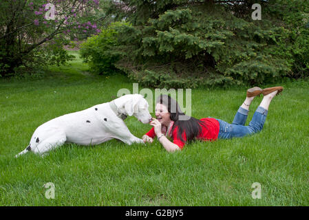 Femme en rouge rit comme elle d'obligations avec big dog Banque D'Images