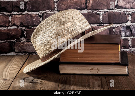 Hat et des livres sur la table en bois brun Banque D'Images