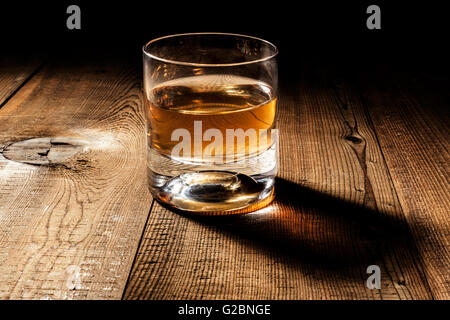 Verre d'alcool sur la table en bois avec ombre Banque D'Images