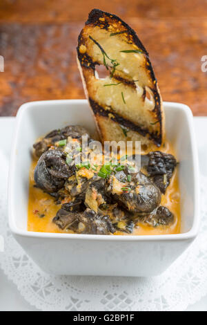 Escargot portugaise avec du pain grillé dans un petit bol blanc. Banque D'Images