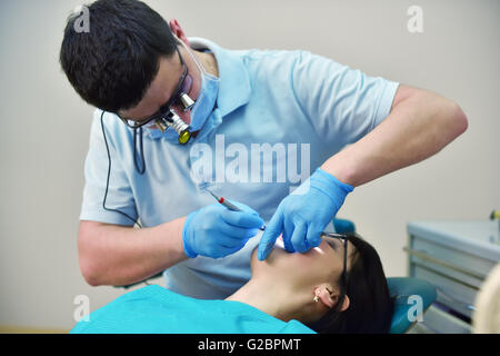 Dentiste examine les dents de la jeune fille Banque D'Images