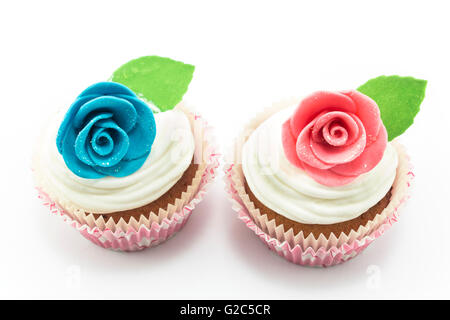 Cupcakes décorés de roses sur un fond blanc. Banque D'Images