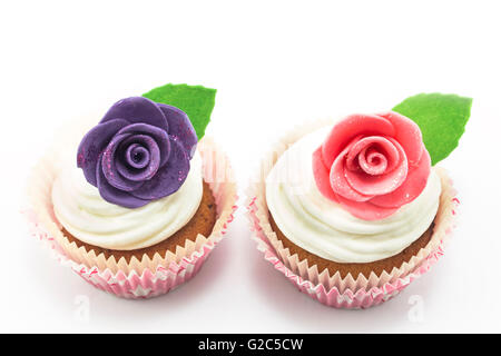 Cupcakes décorés de roses sur un fond blanc. Banque D'Images