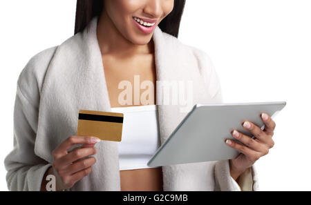 Noir mulâtre woman holding digital tablet computer et payer à partir de la carte de crédit. Vue rapprochée. Isolé sur blanc. Banque D'Images