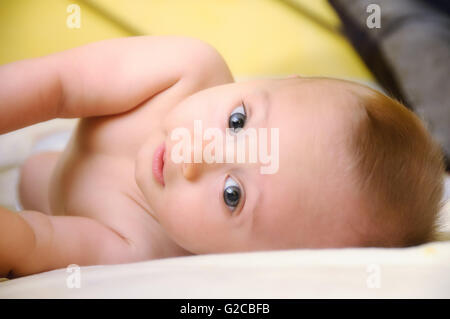 Au lit bébé fond jaune Banque D'Images