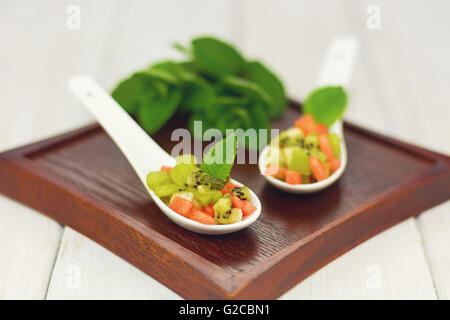 Amuse faite de pastèque banane et kiwi sur la planche de bois Banque D'Images